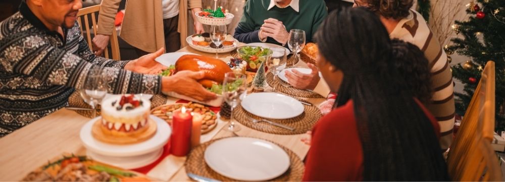 Family sharing holiday meal in festive dining room 
