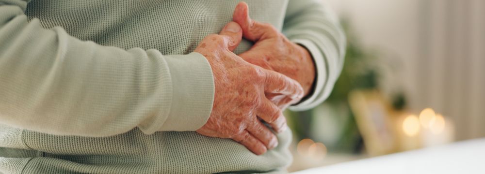 Man with hands folded across stomach