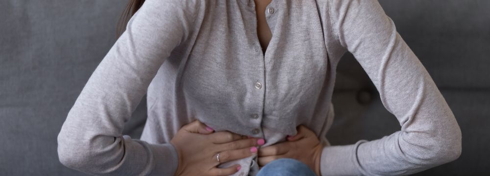 Woman holding stomach clenching in pain
