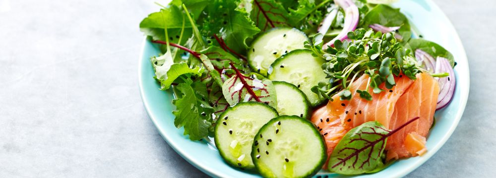 Salad bowl filled with lettuce and vegetables on table