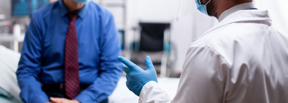 Doctor speaking with patient, patient is seated