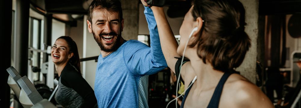 friends working out at the gym together, hi-fiving