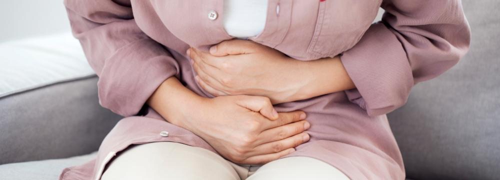 woman clenching abdomen with both hands