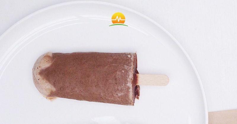 Peanut butter chocolate protein popsicle laying on white plate