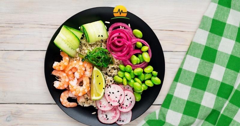 Colorful bowl of shrimp, cucumbers, pickled onions, radish, edamame, and brown rice demonstrate eating for weight loss and health is not boring with MASJax logo at top center.