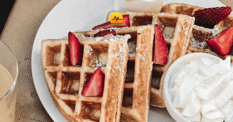 Belgium Waffles with Strawberries and Powered Sugar on White Plate