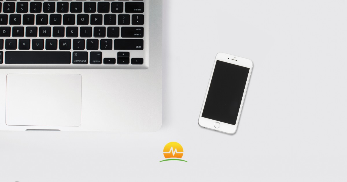 Phone on table next to an open laptop
