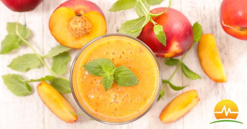 Healthy peach smoothie in center of picture surrounded by fresh peaches. MASJax logo placed in bottom right corner.