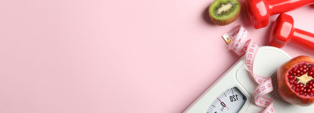 Scale and healthy fruits and vegetable lying on pink backdrop